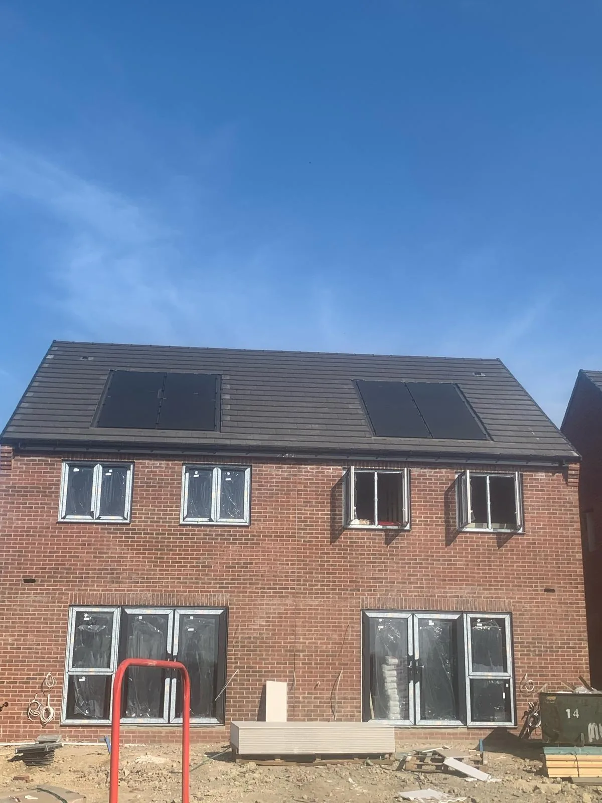 Front elevation of a completed semi-detached pair on the Hay Lane, Spennymoor development showing pitched tiled roof and integrated solar PV.