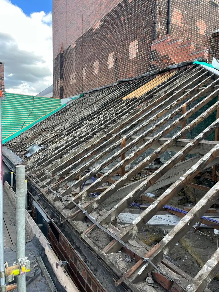 Stripped slate roof at Leeds Grand Theatre showing exposed rafters during the heritage refurbishment, with the secondary covering removed.