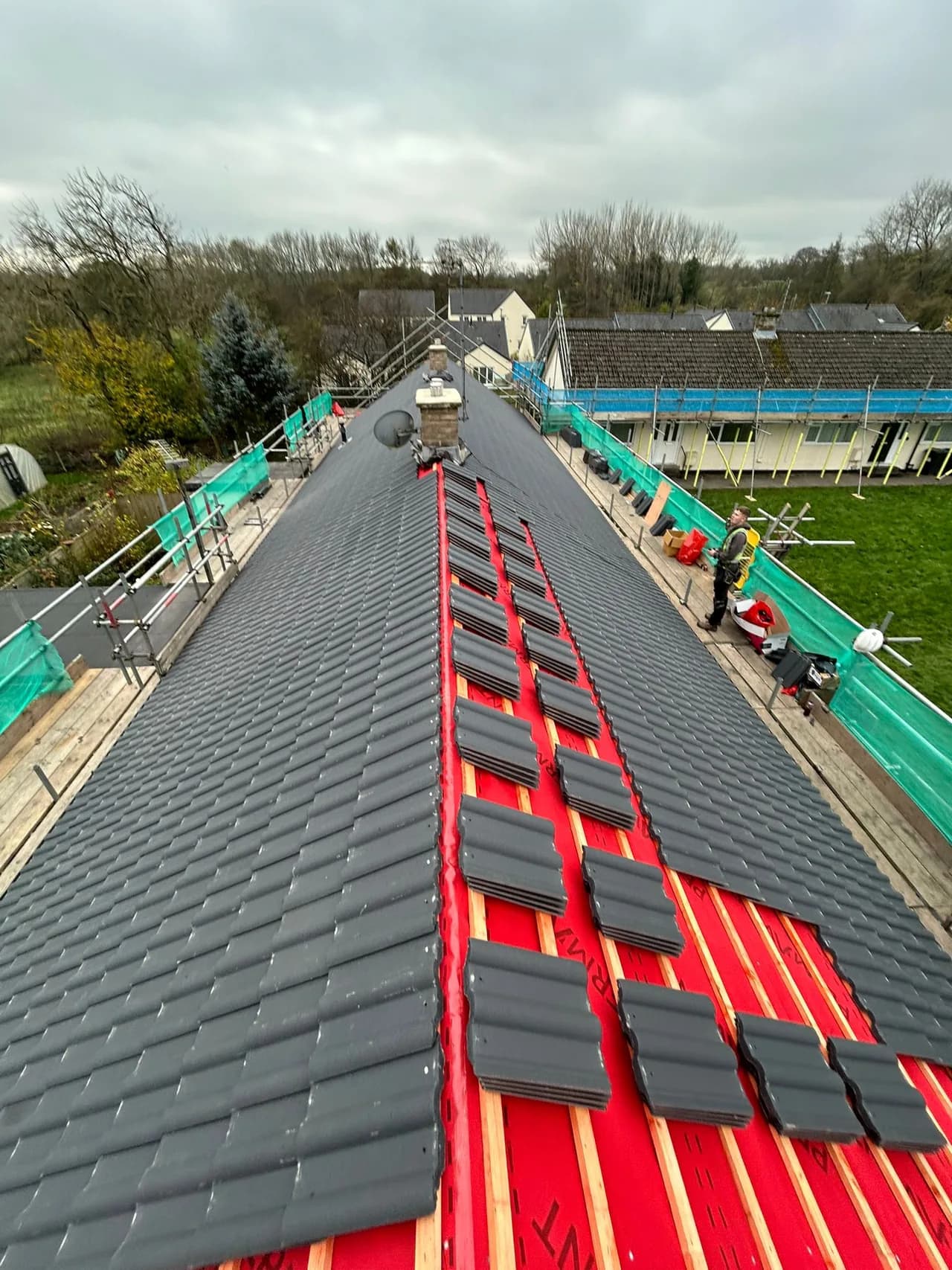 Wide view of multiple bungalows undergoing roof replacement as part of the planned-maintenance programme.